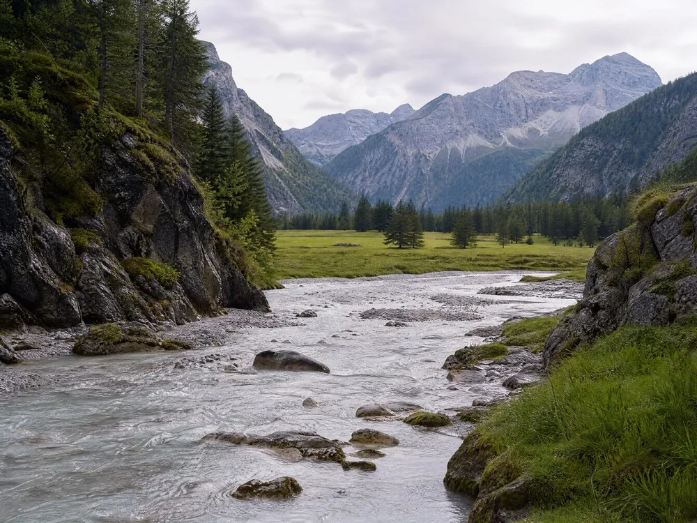 The downstream end of a gorge opening into a broad green valley