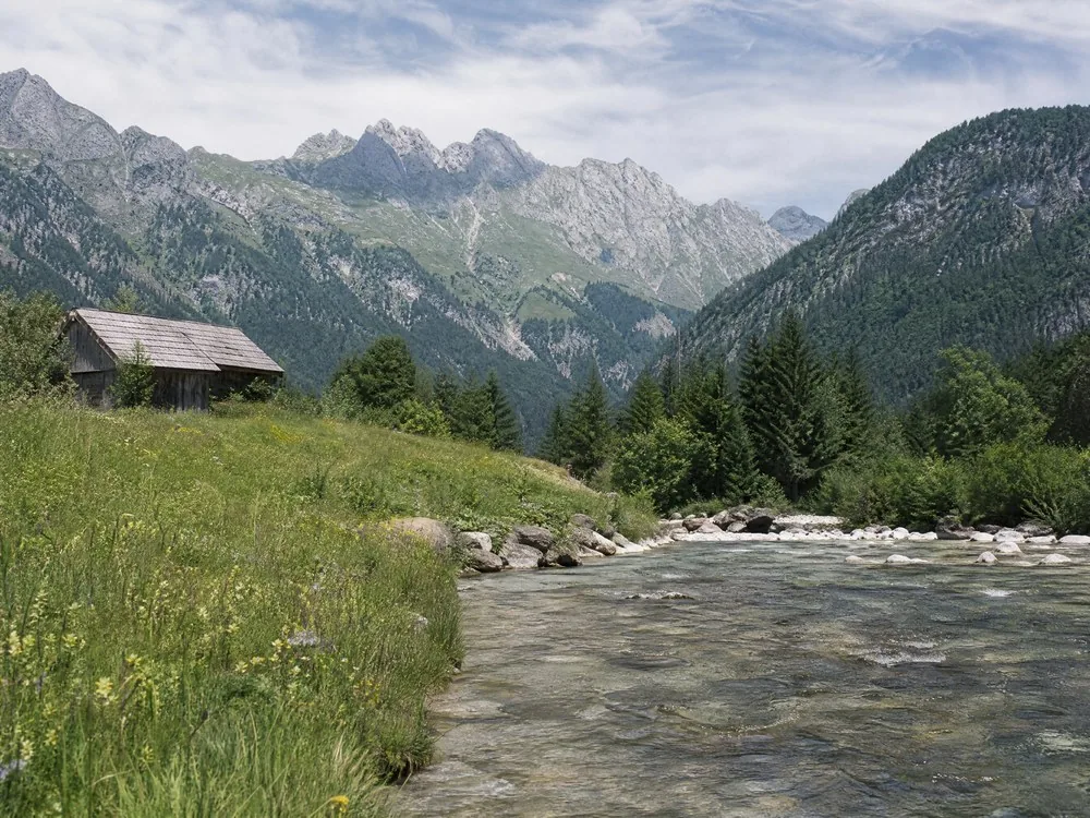An alpine meadow beside a clear river on the walk in